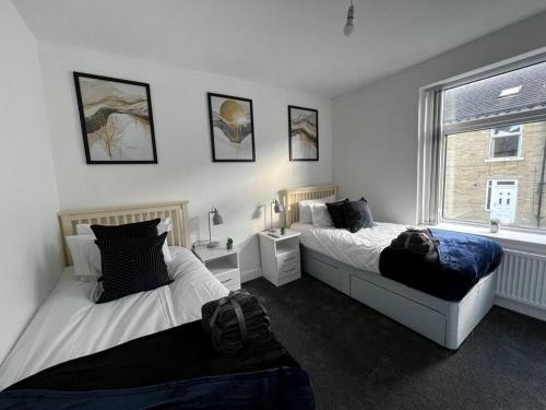 een slaapkamer met 2 bedden en een raam bij Luxe Loft Living: A Home Away From Home in Wibsey