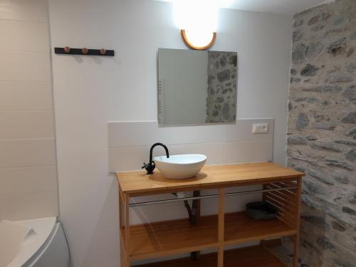 a bathroom with a sink and a mirror on a table at Loft vue montagne in Rigarda