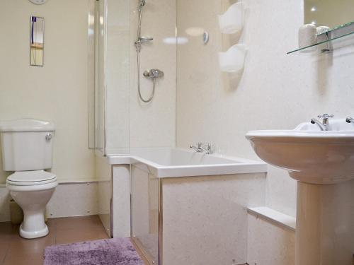 a white bathroom with a sink and a toilet at Meillion Cottage in Letterston