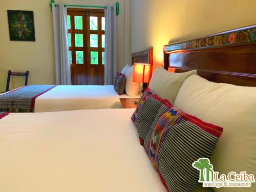 a hotel room with two beds and a window at Hotel La Ceiba in Chiapa de Corzo