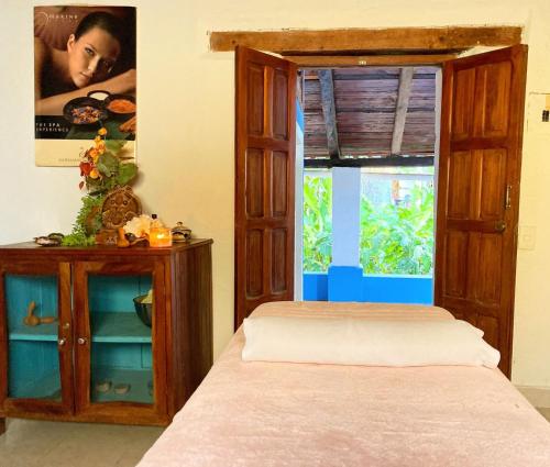 a bedroom with a bed and a cabinet and a window at Hotel La Ceiba in Chiapa de Corzo