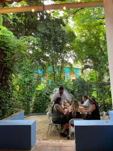 a group of people sitting at a table in a garden at Hotel La Ceiba in Chiapa de Corzo