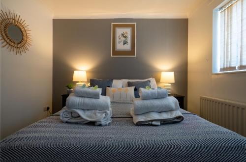 Peacehaven的住宿－Get Away Home With Hot Tub Sleeps 4，一间卧室配有一张带蓝色枕头的床。