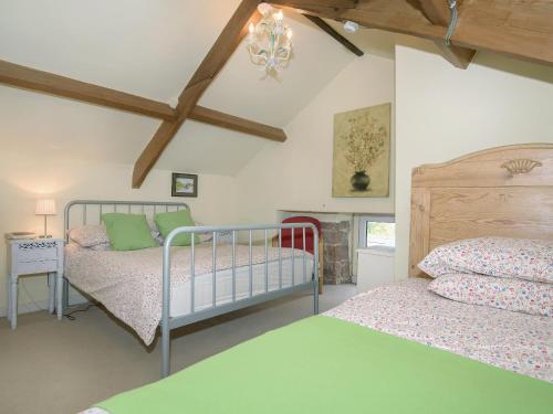 a bedroom with two beds and a fireplace at Edderside Hall in Mawbray