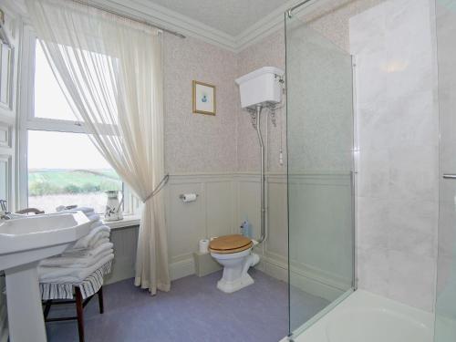 a bathroom with a toilet and a glass shower at Edderside Hall in Mawbray