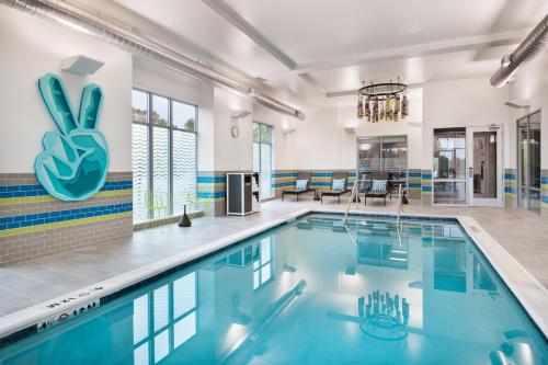 a pool in a large room with a swimming pool at Aloft Lawrenceville Sugarloaf in Lawrenceville