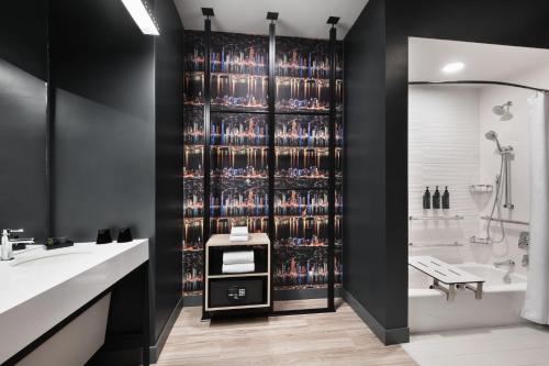 a bathroom with a wall of wine bottles at Aloft Lawrenceville Sugarloaf in Lawrenceville