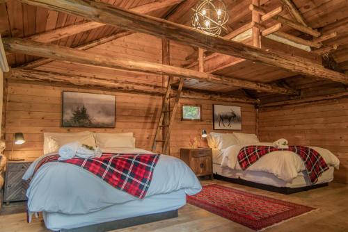 a bedroom with two beds in a log cabin at Chute Lake Lodge in Naramata