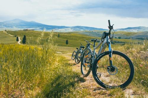 a group of bikes parked on a trail in a field at BOUTIQUE VILLA LIBERTY - Dépendance - Borgo Capitano Collection - Albergo diffuso in San Quirico dʼOrcia