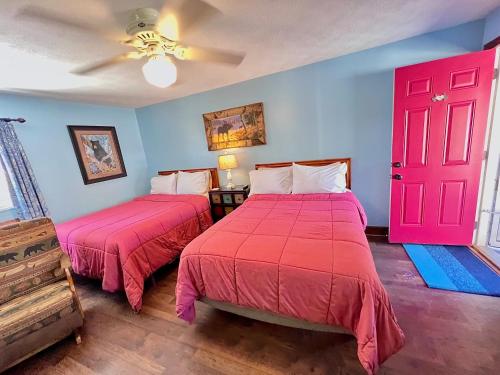 a bedroom with two beds and a red door at Homestead Inn - Blowing Rock in Blowing Rock