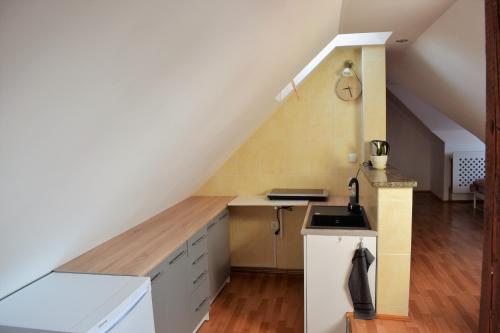 an attic kitchen with a sink and a staircase at Apartament Starówka in Tuchola