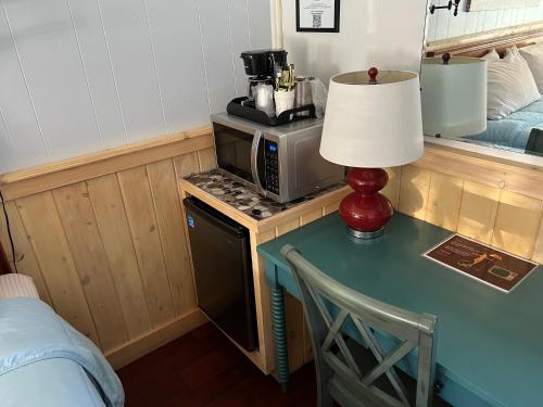 a table with a lamp and a microwave in a room at Homestead Inn - Blowing Rock in Blowing Rock