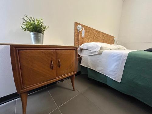 a bedroom with a bed and a dresser with a plant on it at 87029house in Scalea