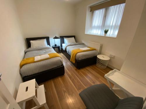 ein Zimmer mit 2 Betten und einem Stuhl darin in der Unterkunft 3 Bed apartment in Camden in London