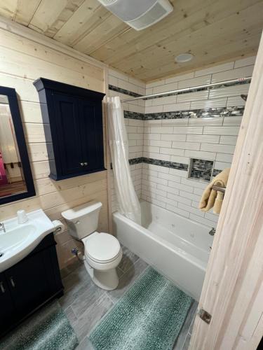 a bathroom with a toilet and a tub and a sink at Homestead Inn - Blowing Rock in Blowing Rock