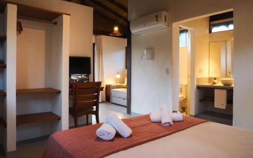 een slaapkamer met een bed met twee handdoeken erop bij Manawa Bangalôs in Serra Grande