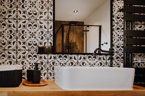 a bathroom with a white tub and a black and white wallpaper at Sarnia Skała House in Zakopane
