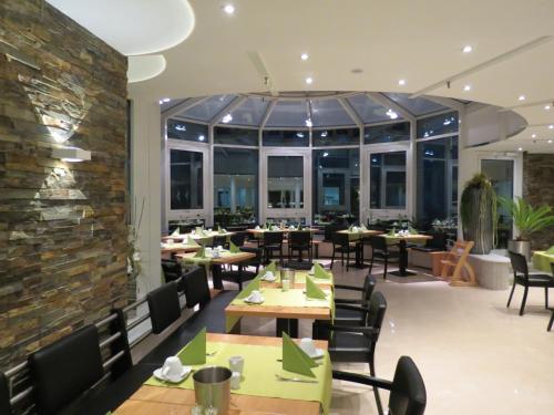 a restaurant with tables and chairs and a brick wall at Comfor Hotel Ulm City in Ulm