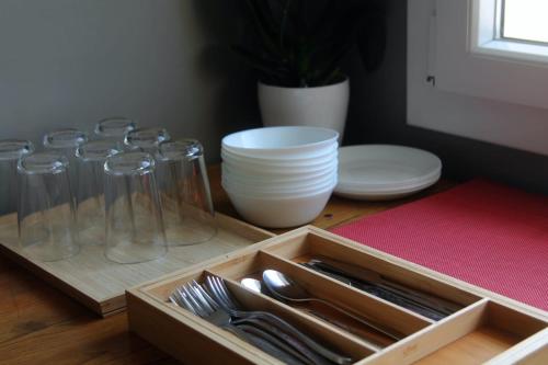 a wooden tray with glasses and utensils on a table at B&B Gasper in Cavalcaselle