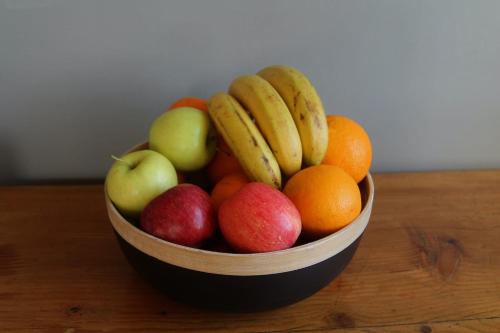 a wooden bowl of fruit on a wooden table at B&B Gasper in Cavalcaselle