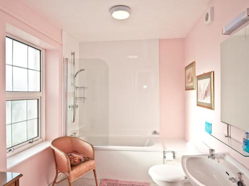 GreystokeにあるAlgars Garth- 28085のピンクのバスルーム(バスタブ、椅子付)