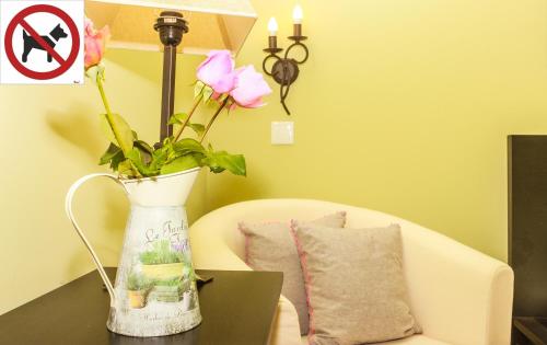 a vase with flowers on a table next to a couch at Casa da Tita in Salir