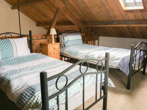 two twin beds in a room with a attic at Heron in Welney