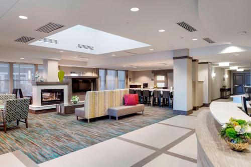 a lobby of a hotel with a fireplace and chairs at Residence Inn by Marriott Bath Brunswick Area in Bath