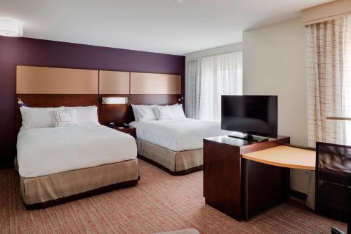a hotel room with two beds and a flat screen tv at Residence Inn by Marriott Bath Brunswick Area in Bath