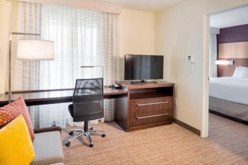 a hotel room with a desk with a television and a bed at Residence Inn by Marriott Bath Brunswick Area in Bath