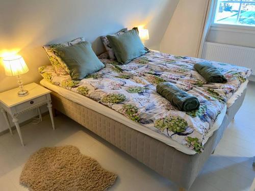 a bed with pillows on it in a room with a window at Otavalan ullakko in Tampere
