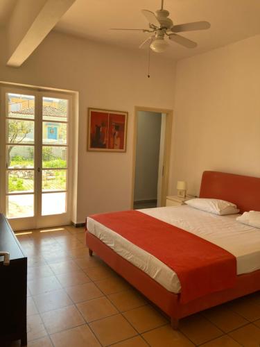 Schlafzimmer mit einem Bett und einem Deckenventilator in der Unterkunft Mediterranean house with beautiful garden in Karlovasi