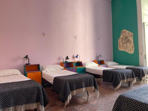 ナポリにある6 Small Roomsのベッド3台が備わる部屋
