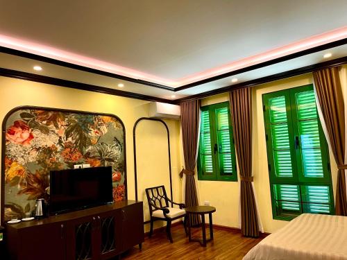 a bedroom with a bed and a tv and some windows at Moonlight Hotel Sa Pa in Sa Pa