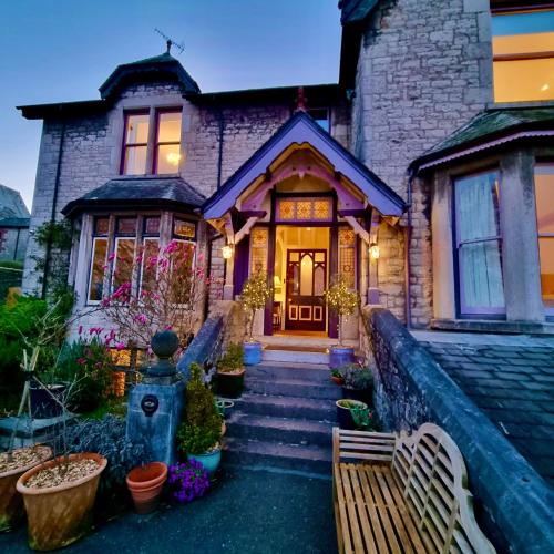 a brick house with a bench in front of it at Grange Boutique Hotel in Grange Over Sands