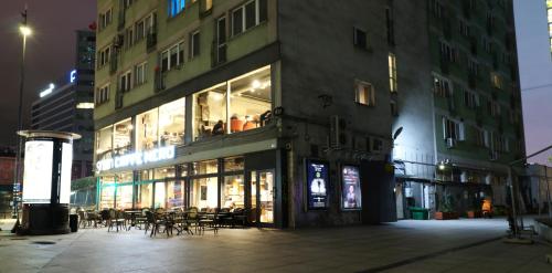 a building with tables and chairs on a city street at night at Falcon Apartment Center 2 Metro Złote Tarasy in Warsaw