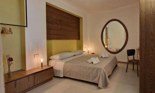 a bedroom with a large bed and a mirror at alsùd Dimora di Lampedusa in Lampedusa