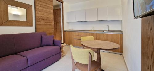 a living room with a purple couch and a table at alsùd Dimora di Lampedusa in Lampedusa