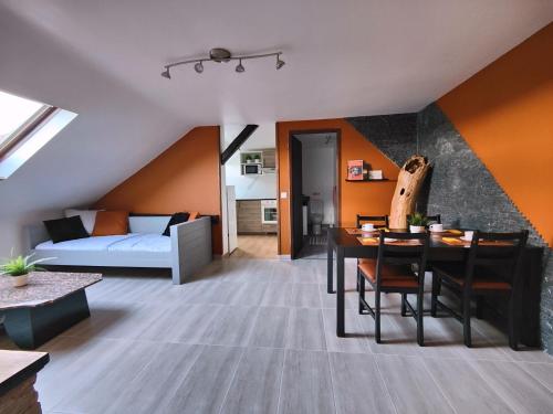 a living room with a bed and a dining table at Private & Comfortable Apartments in Puttelange-aux-Lacs