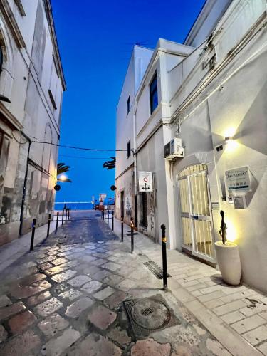 an empty street with buildings and the ocean in the background at La Maison Arco Boccolicchio in Manfredonia