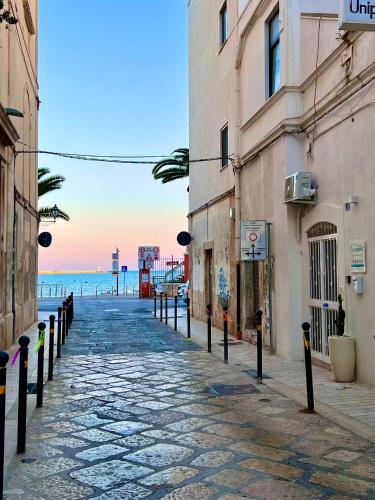 a cobblestone street next to the ocean with buildings at La Maison Arco Boccolicchio in Manfredonia