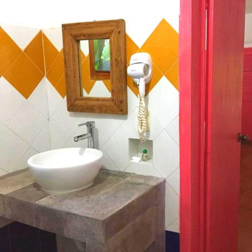 a bathroom with a sink and a mirror and a hair dryer at Hotel La Ceiba in Chiapa de Corzo