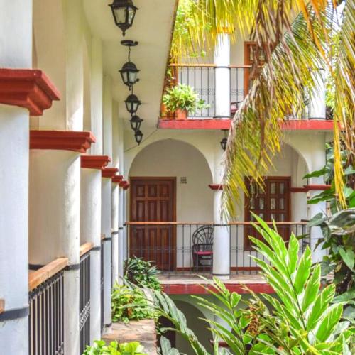 a courtyard of a building with balconies and plants at Hotel La Ceiba in Chiapa de Corzo