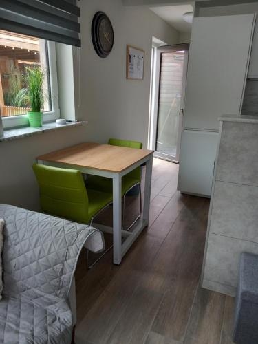a dining room with a table and green chairs at "Ter Ename n°2" in Oudenaarde