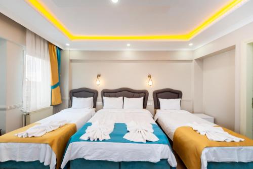 a bedroom with two beds and a yellow ceiling at Kadirga Studios Renovated in 2023 in Istanbul