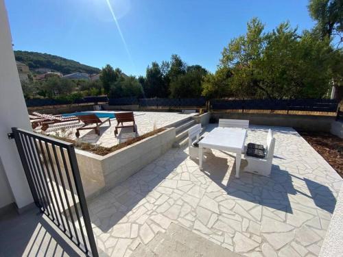 a patio with a table and a bench on it at Apartment Isla with heated pool,center, near the beach in Preko