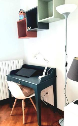 a black desk with a lamp and a white chair at Interno 15 Diario di viaggio in Vigevano