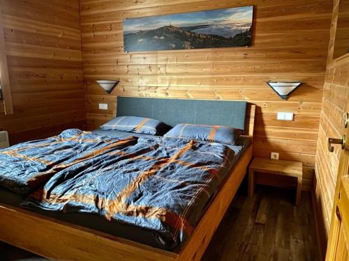 a bedroom with a bed in a wooden wall at Ferienhaus Nr 6, Typ A, Feriendorf Jägerpark, Bayerischer Wald in Viechtach