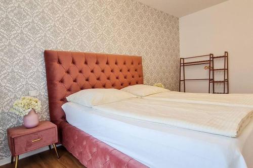 a bed with a red headboard in a bedroom at Luxus Wohnung im Stadtzentrum in Nuremberg
