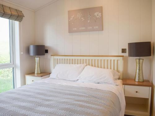 Kinlet的住宿－Lodge 5，一间卧室配有一张带两张台灯的床铺。